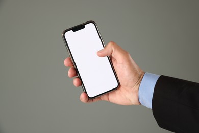 Photo of Man with modern smartphone on grey background, closeup. Mockup for design