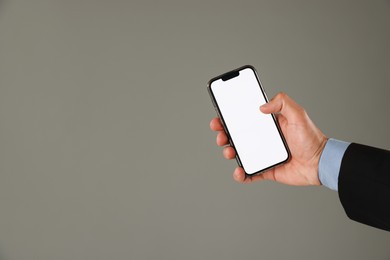 Photo of Man with modern smartphone on grey background, closeup. Mockup for design