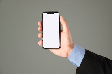 Photo of Man with modern smartphone on grey background, closeup. Mockup for design