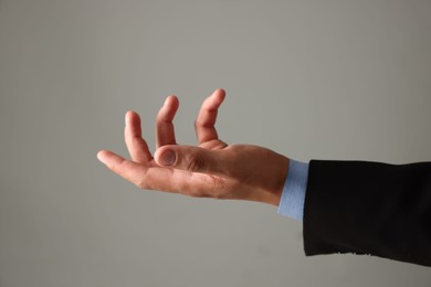 Photo of Man holding something on grey background, closeup