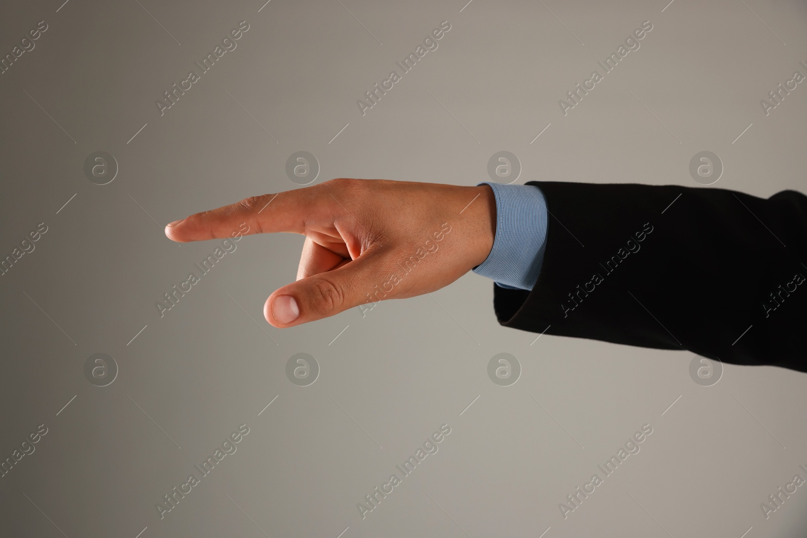 Man touching something on grey background, closeup Photo of Man touching something on grey background, closeup