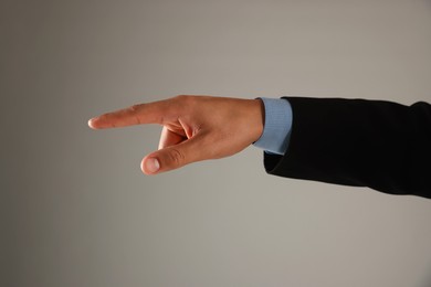 Photo of Man touching something on grey background, closeup