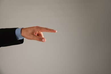 Photo of Man touching something on grey background, closeup