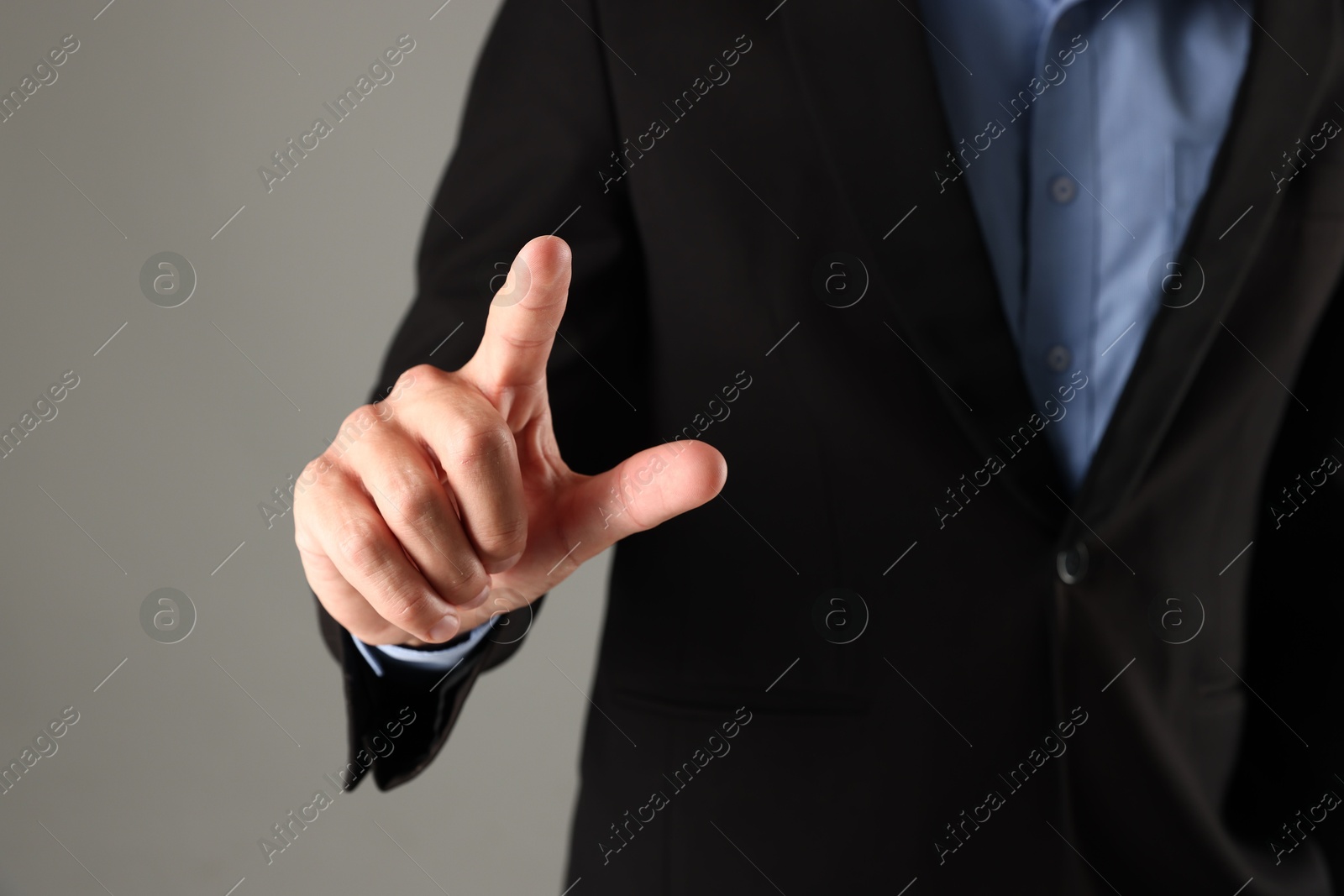 Man touching something on grey background, closeup Photo of Man touching something on grey background, closeup