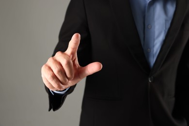 Photo of Man touching something on grey background, closeup