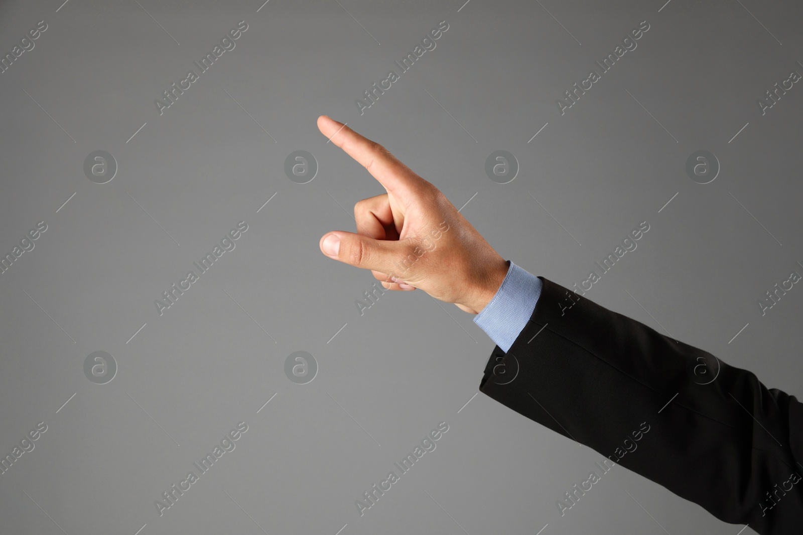 Man touching something on grey background, closeup. Space for text Photo of Man touching something on grey background, closeup. Space for text