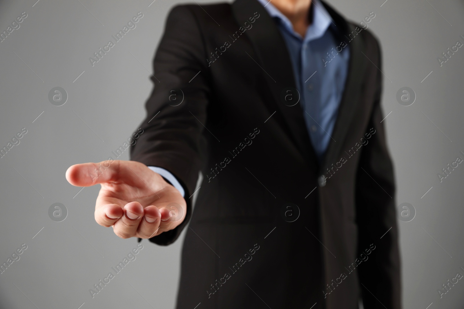 Photo of Man holding something on grey background, closeup