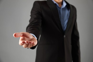 Photo of Man holding something on grey background, closeup