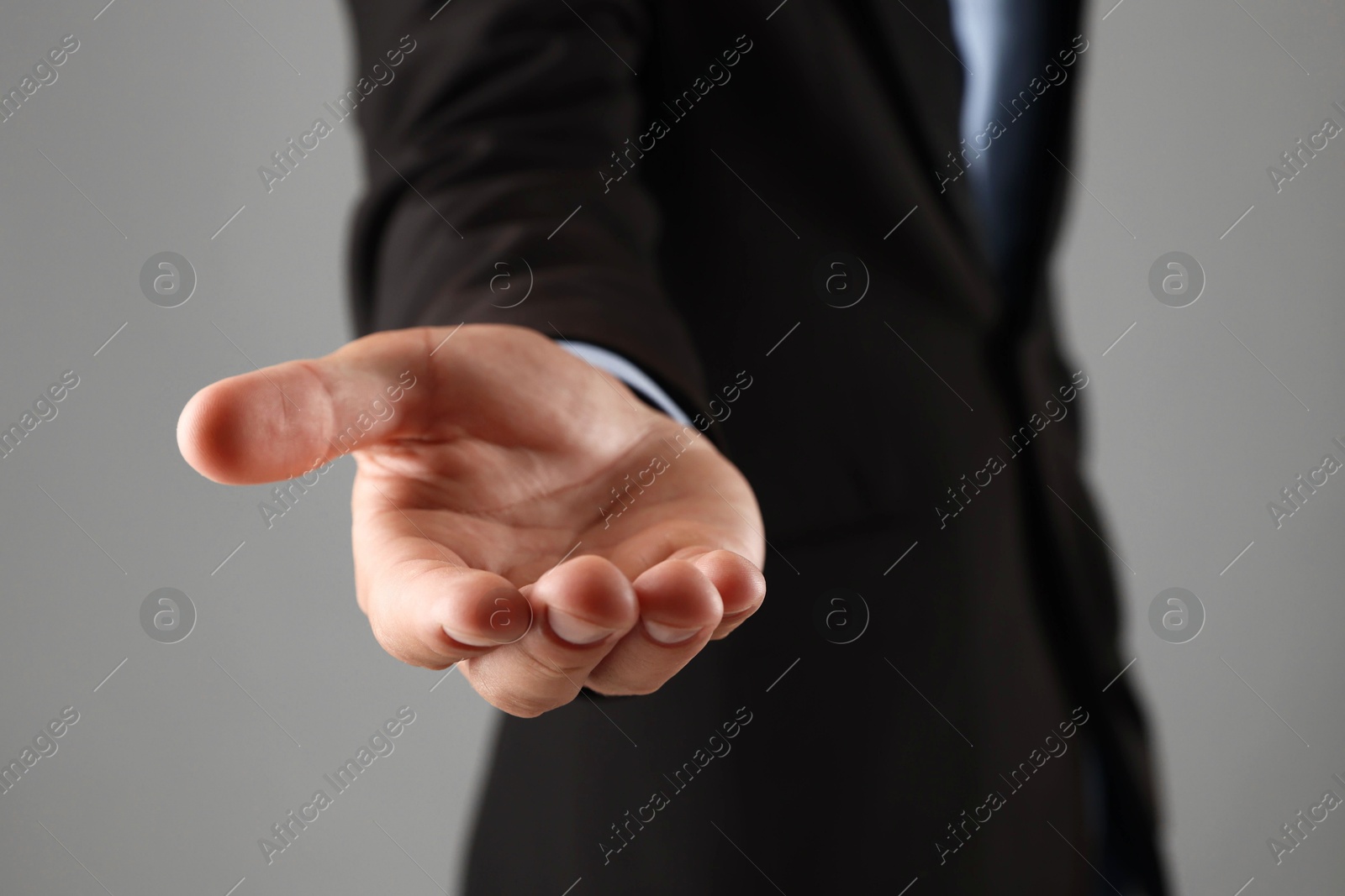Photo of Man holding something on grey background, closeup