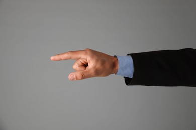 Photo of Man touching something on grey background, closeup