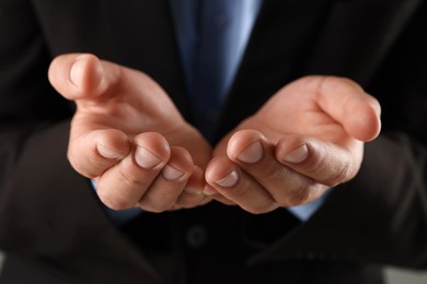 Photo of Man holding something on grey background, closeup