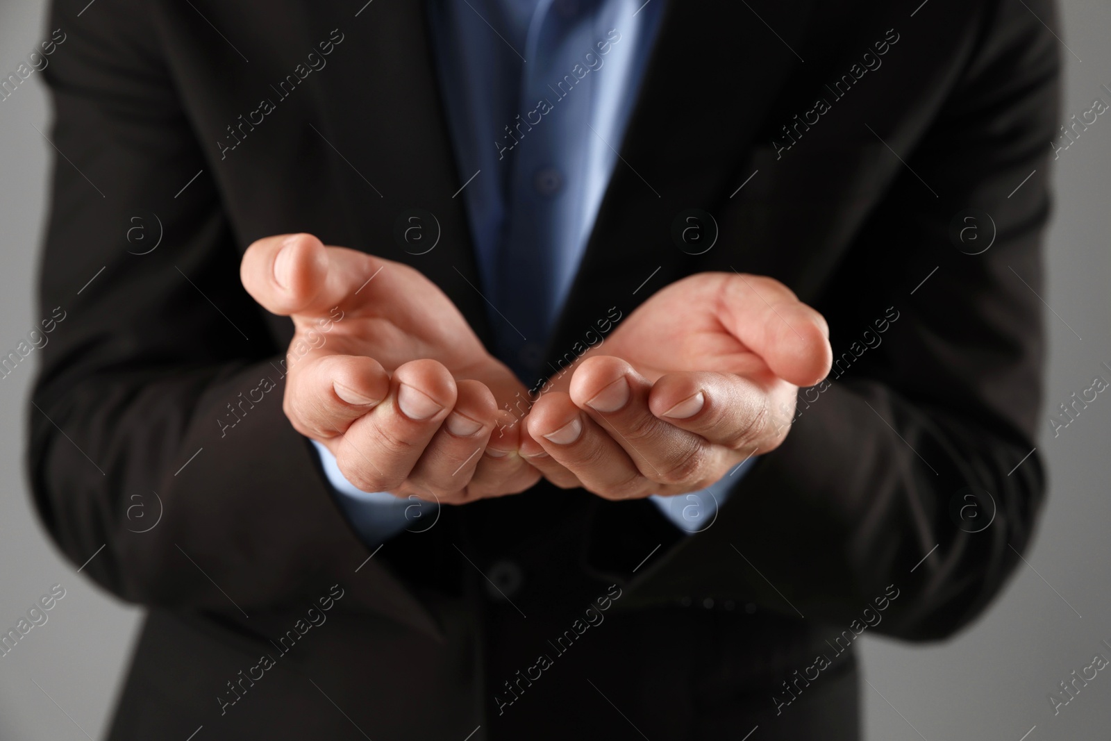 Photo of Man holding something on grey background, closeup