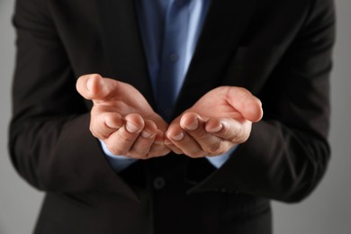 Photo of Man holding something on grey background, closeup