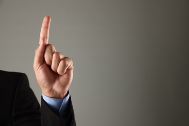 Photo of Man touching something on grey background, closeup. Space for text