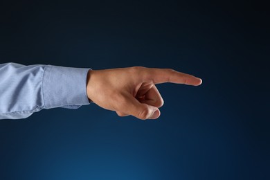 Photo of Man touching something on blue background, closeup