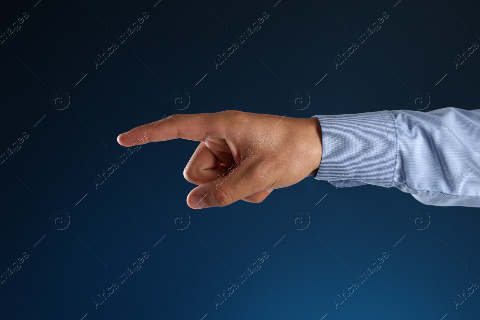 Man touching something on blue background, closeup Photo of Man touching something on blue background, closeup