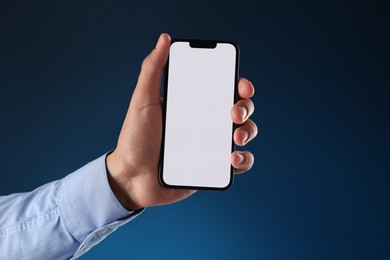 Photo of Man with modern smartphone on blue background, closeup. Mockup for design