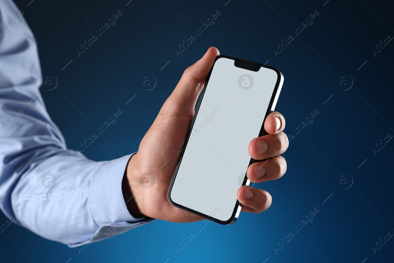 Man with modern smartphone on blue background, closeup. Mockup for design Photo of Man with modern smartphone on blue background, closeup. Mockup for design