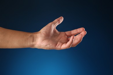 Photo of Man holding something on blue background, closeup