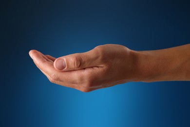 Photo of Man holding something on blue background, closeup