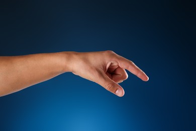 Photo of Man touching something on blue background, closeup