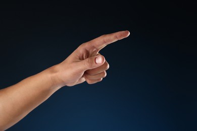 Photo of Man touching something on blue background, closeup