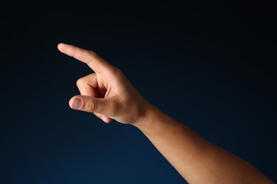 Photo of Man touching something on blue background, closeup