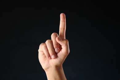 Photo of Man touching something on black background, closeup