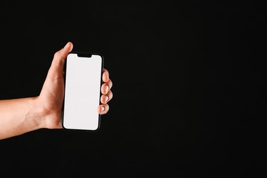 Photo of Man with modern smartphone on black background, closeup. Mockup for design