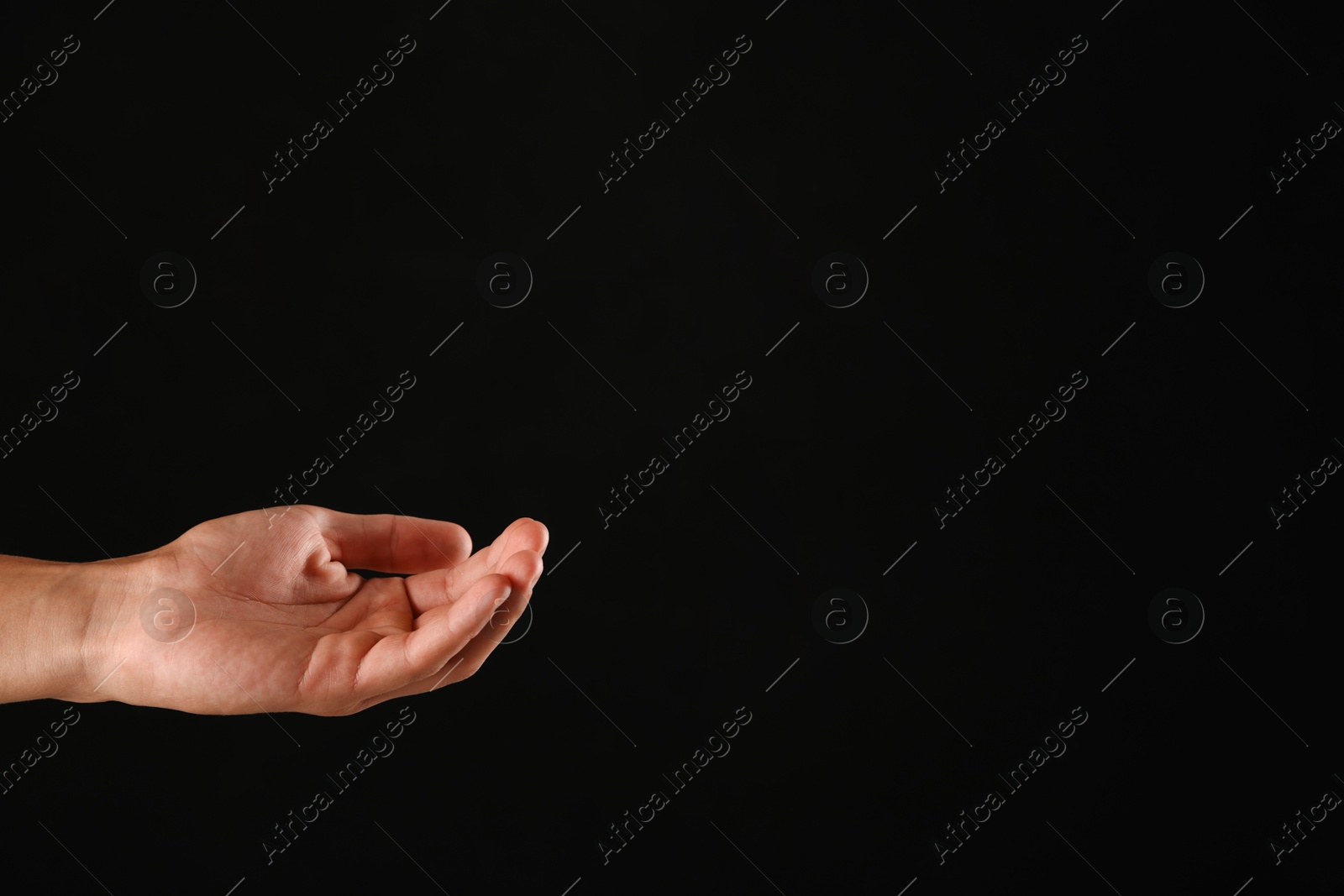 Photo of Man holding something on black background, closeup. Space for text