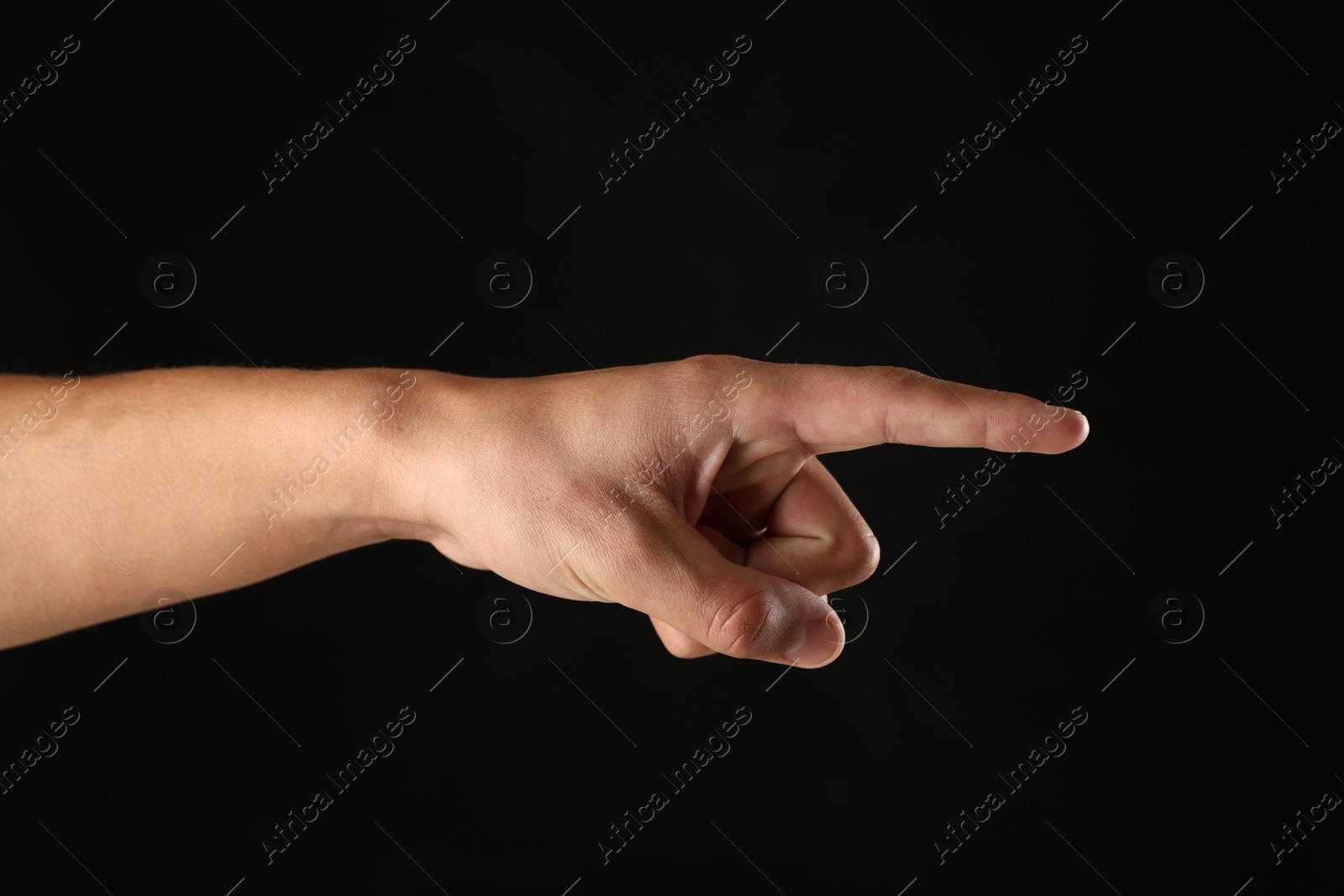 Man touching something on black background, closeup Photo of Man touching something on black background, closeup