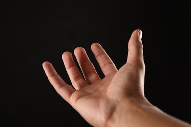 Photo of Man holding something on black background, closeup