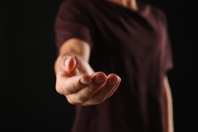 Photo of Man holding something on black background, closeup