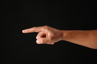 Photo of Man touching something on black background, closeup