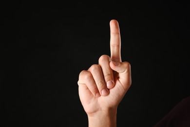 Photo of Man touching something on black background, closeup