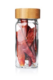 Photo of Dried red peppers in glass jar isolated on white. Aromatic spice