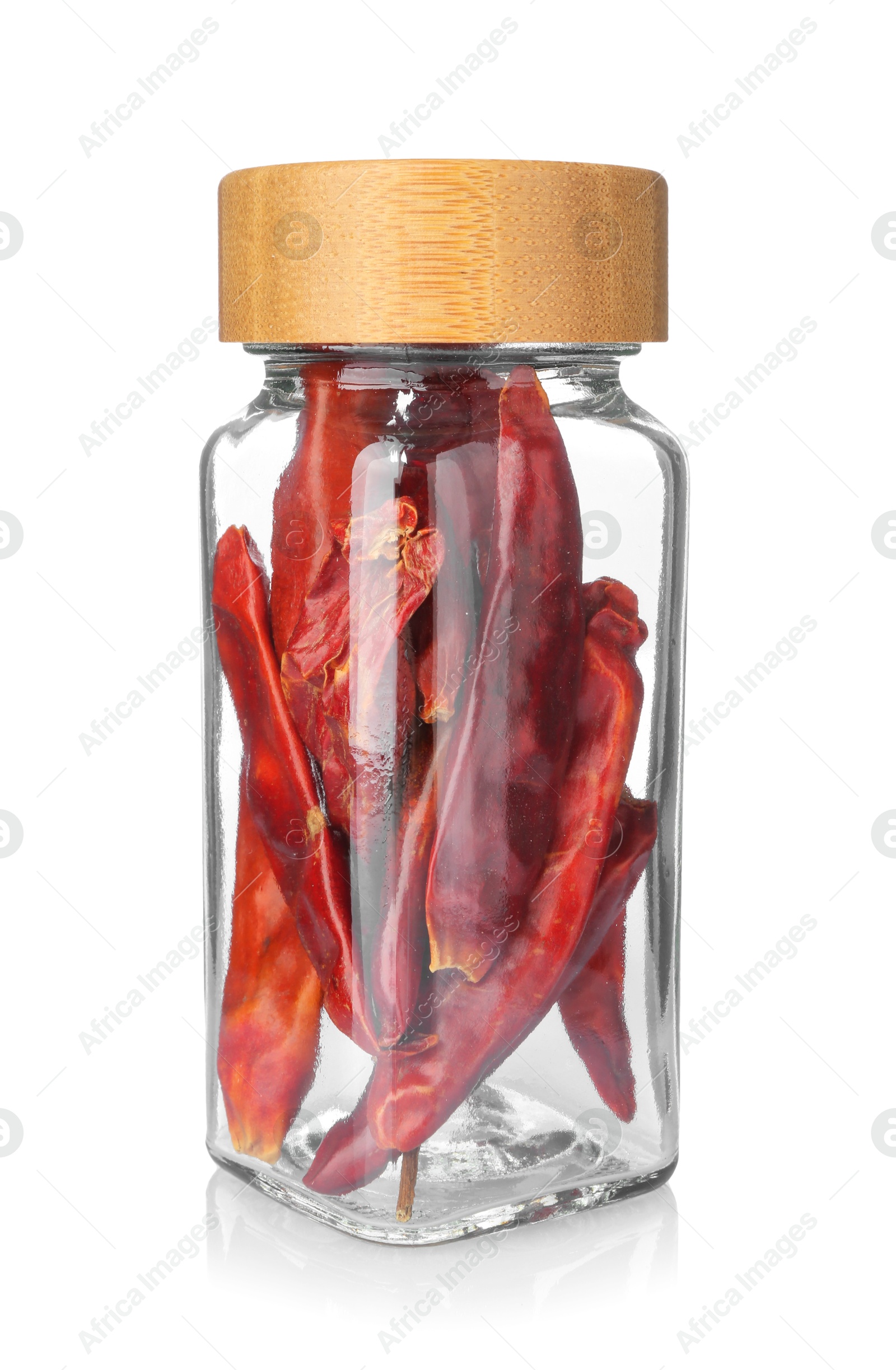 Photo of Dried red peppers in glass jar isolated on white. Aromatic spice