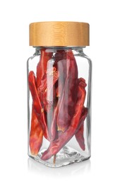 Photo of Dried red peppers in glass jar isolated on white. Aromatic spice
