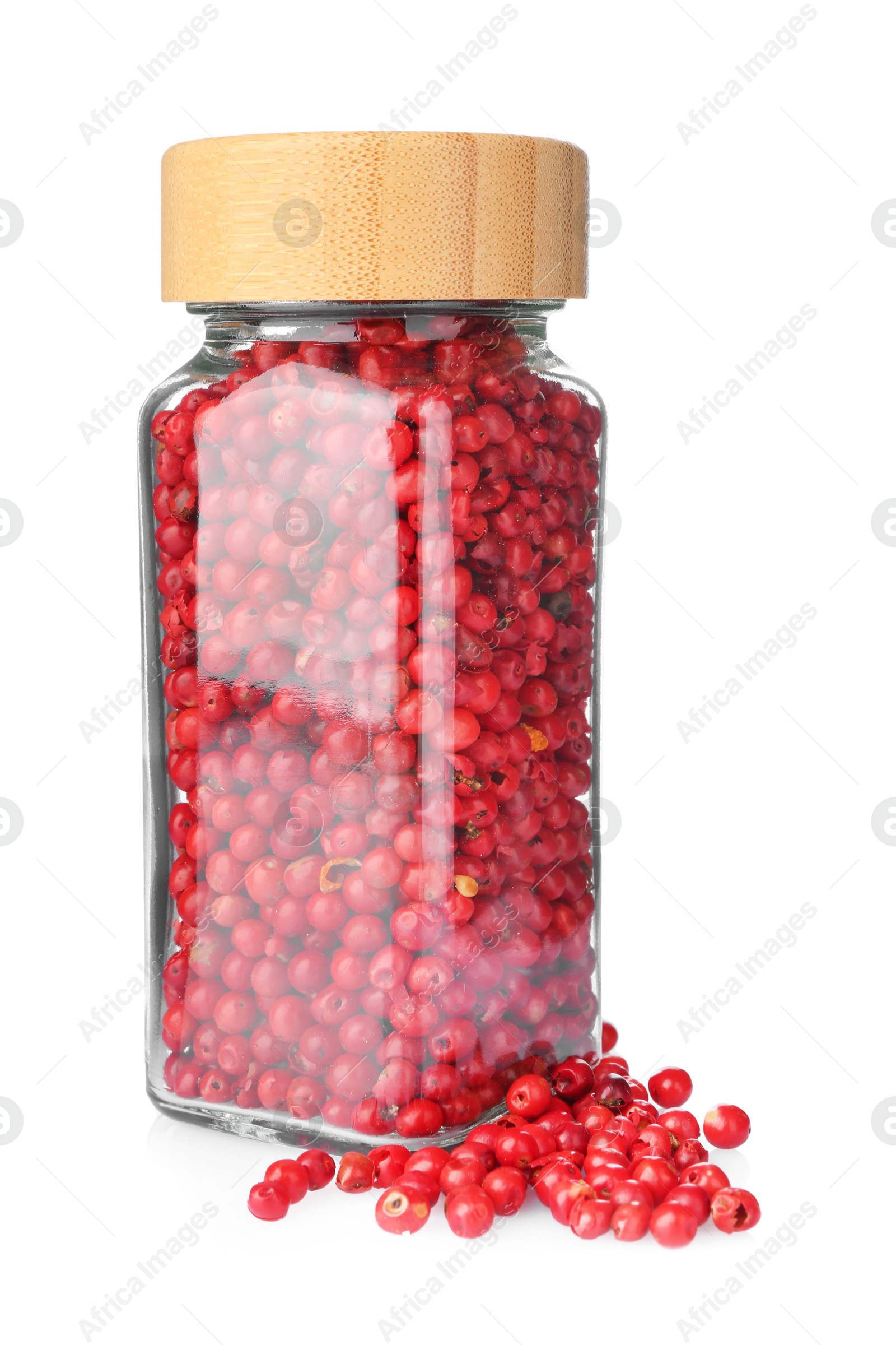 Photo of Red peppercorns in glass jar isolated on white. Aromatic spice