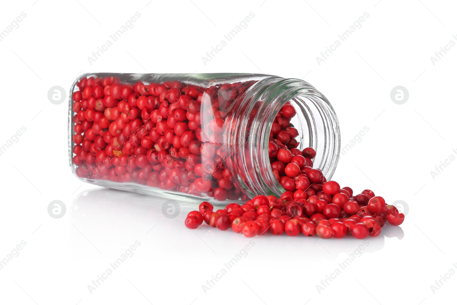 Photo of Red peppercorns in glass jar isolated on white. Aromatic spice