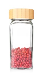Photo of Red peppercorns in glass jar isolated on white. Aromatic spice