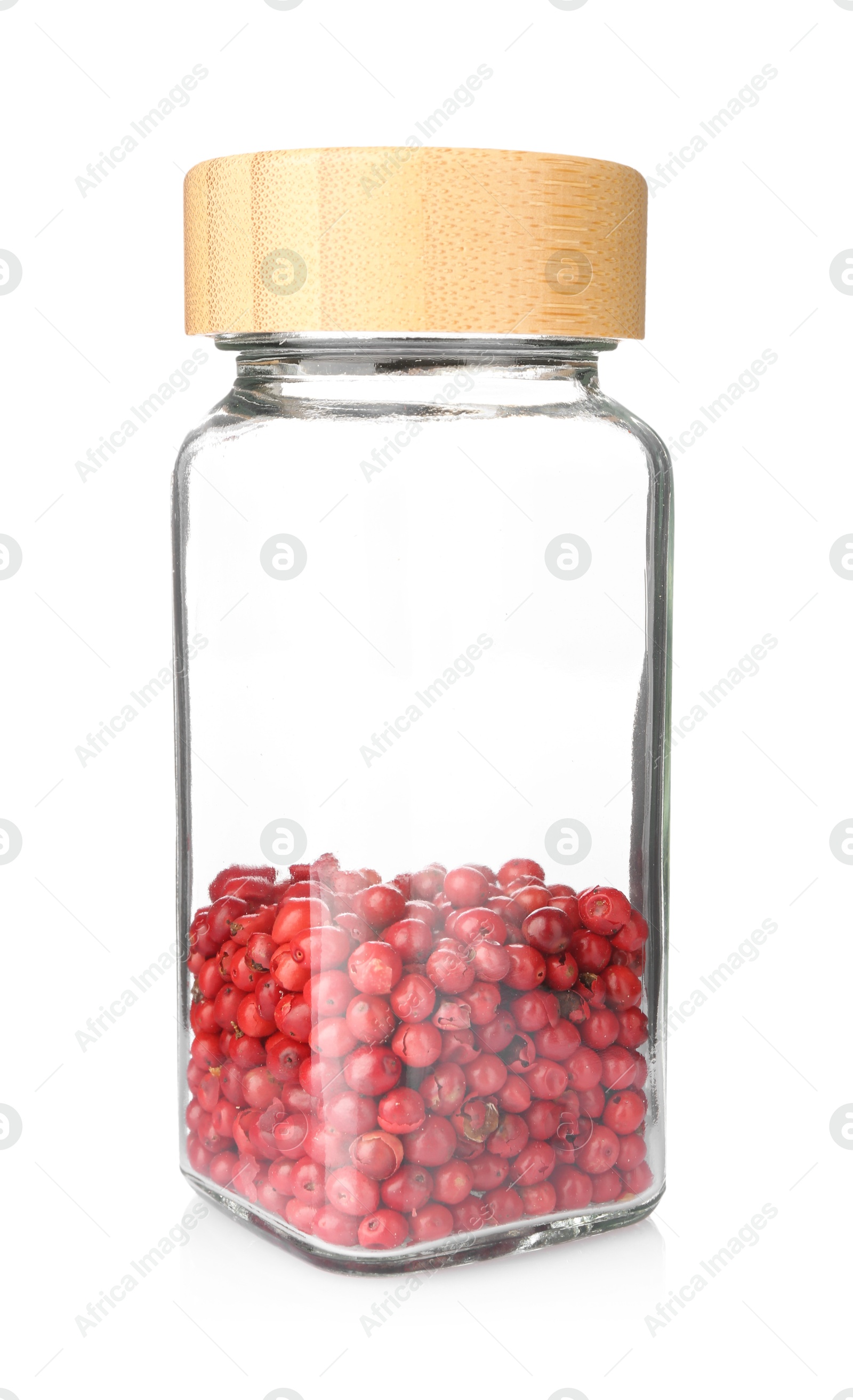Red peppercorns in glass jar isolated on white. Aromatic spice Photo of Red peppercorns in glass jar isolated on white. Aromatic spice