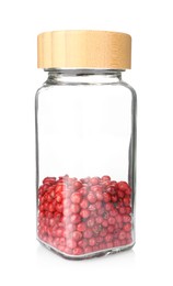 Photo of Red peppercorns in glass jar isolated on white. Aromatic spice