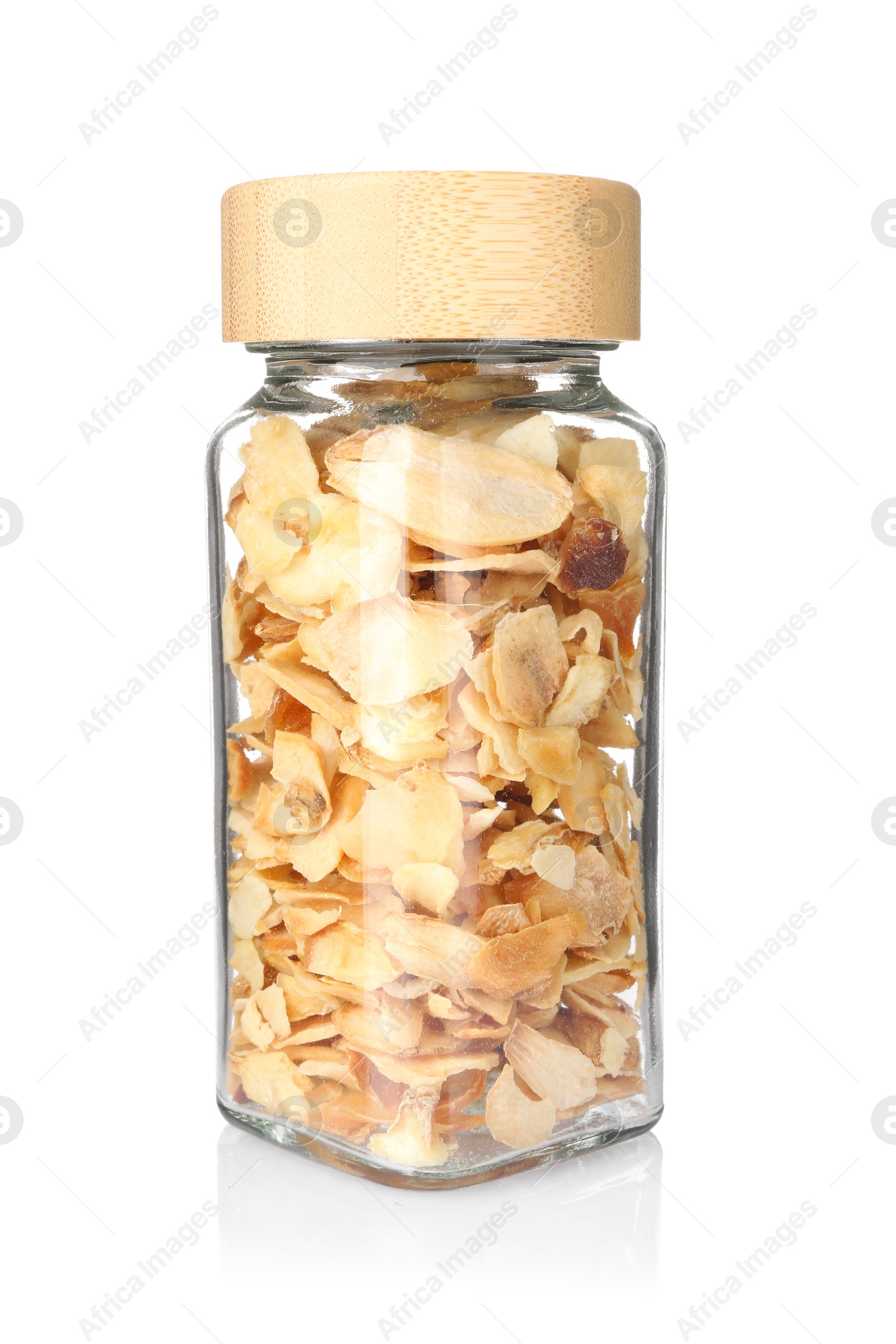 Photo of Dried garlic flakes in glass jar isolated on white. Aromatic spice