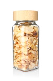 Photo of Dried garlic flakes in glass jar isolated on white. Aromatic spice