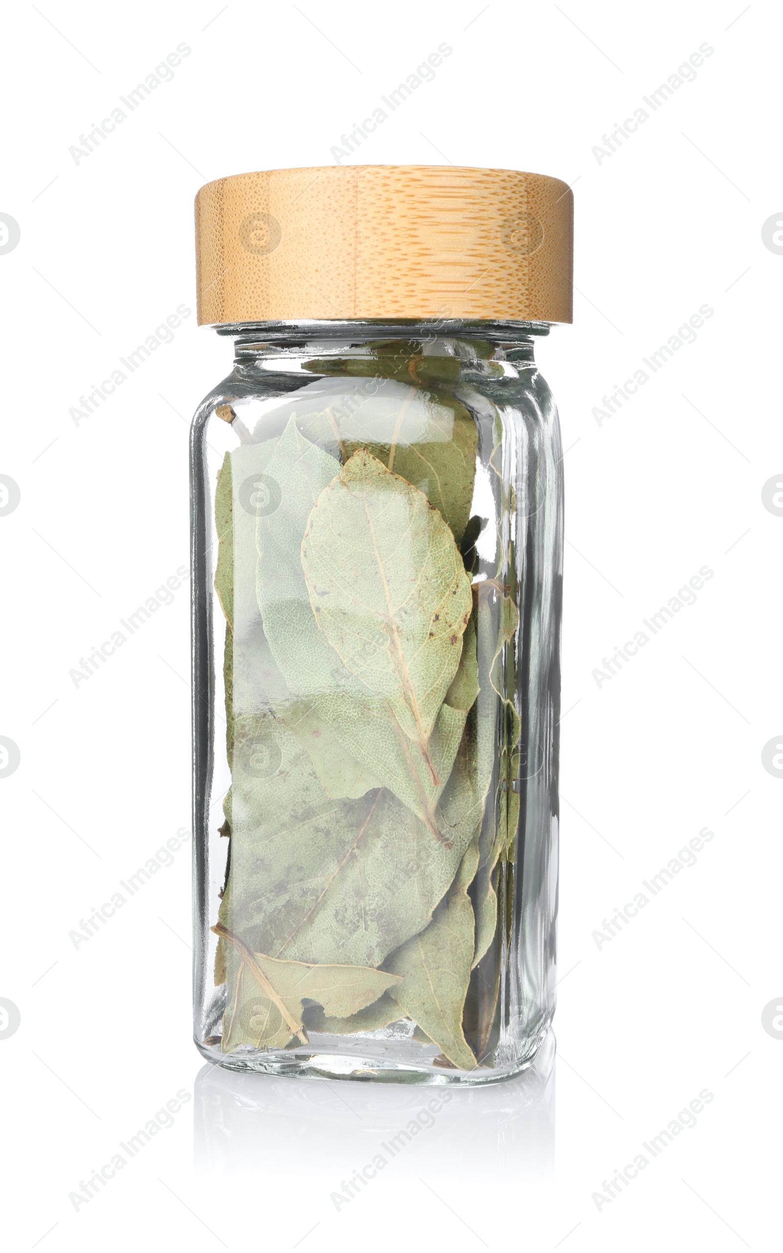 Photo of Dried bay leaves in glass jar isolated on white. Aromatic spice