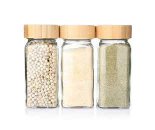 Photo of Different aromatic spices in glass jars isolated on white