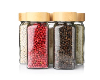 Photo of Different aromatic spices in glass jars isolated on white