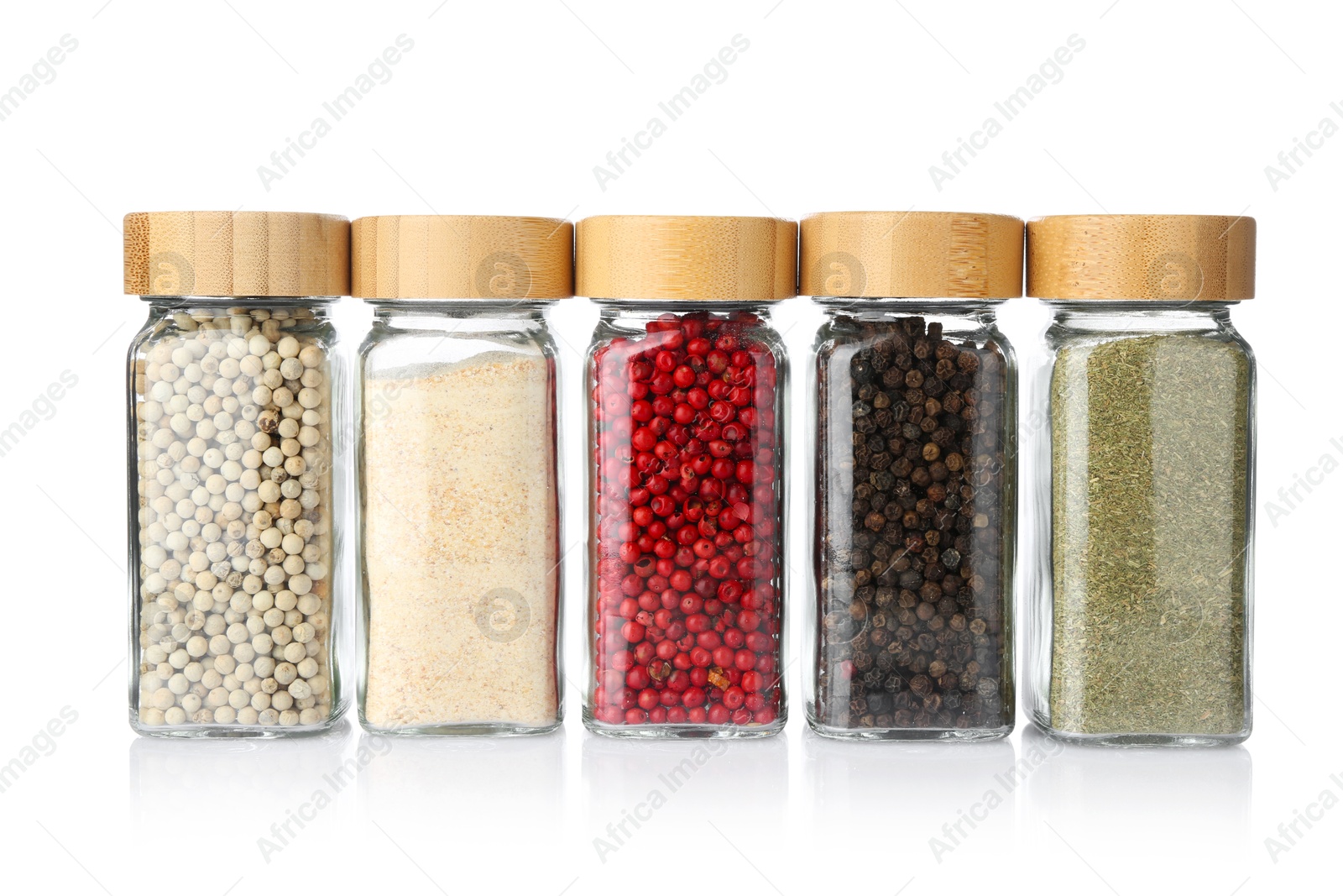 Photo of Different aromatic spices in glass jars isolated on white
