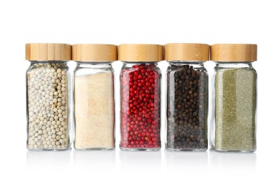 Photo of Different aromatic spices in glass jars isolated on white